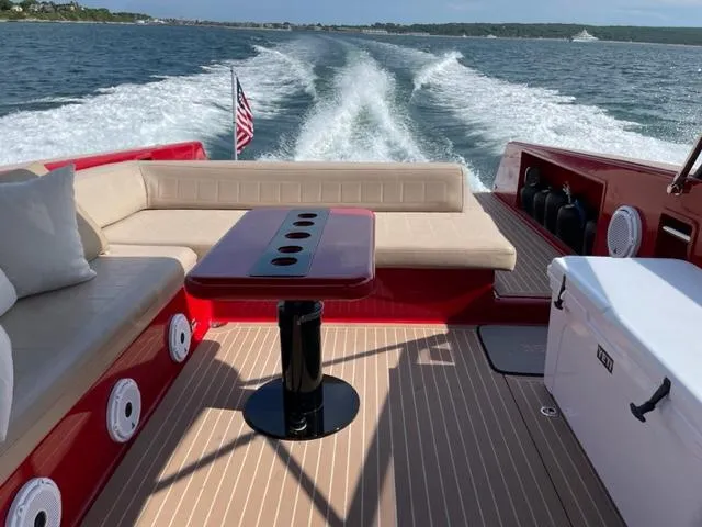 Slide: The Image of VanDutch 40 yacht interior with beige seating, red accents, and ocean view. - 7