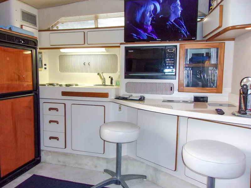 Slide: The Image of Interior of 1992 Sea Ray 400 Express Cruiser with kitchen and seating area. - 14