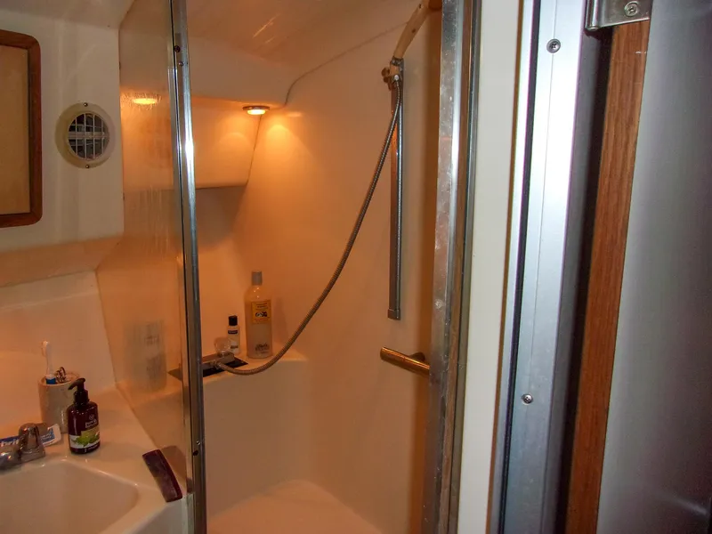Slide: The Image of 1992 Sea Ray 400 Express Cruiser bathroom with shower and toiletries. - 23