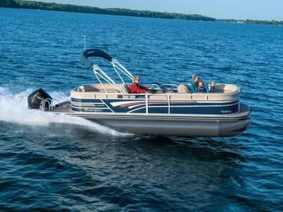 The Image of 2023 Ranger 243C pontoon boat cruising on a lake with passengers. - 1