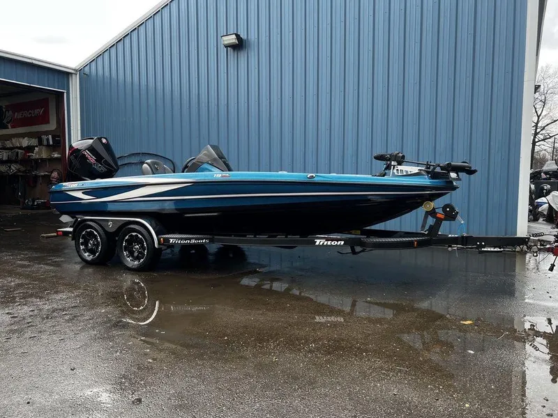 Slide: The Image of 2017 Triton 19 TrX boat on trailer beside blue building. - 11