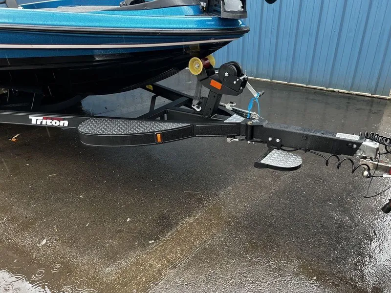 Slide: The Image of 2017 Triton 19 TrX boat trailer hitch on wet pavement. - 6
