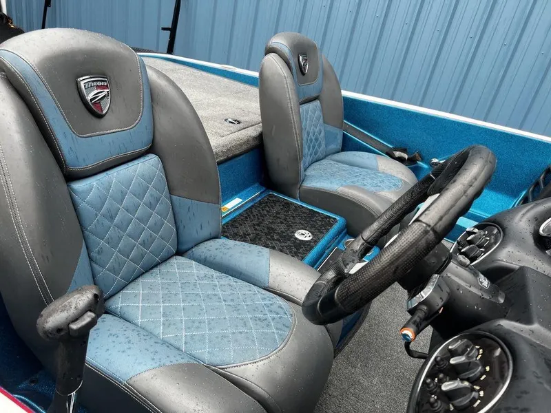 Slide: The Image of 2017 Triton 19 TrX boat interior with blue and gray seats, steering wheel, and dashboard. - 8