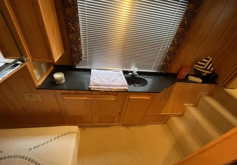 Slide: The Image of Sumerset 16x75 houseboat interior with sink, wooden cabinets, and carpeted stairs, year 2000. - 12