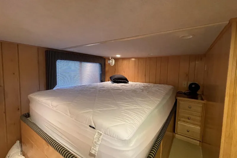 Slide: The Image of Cozy bedroom in 2000 Sumerset 16x75 houseboat with wood paneling and comfortable bed. - 15