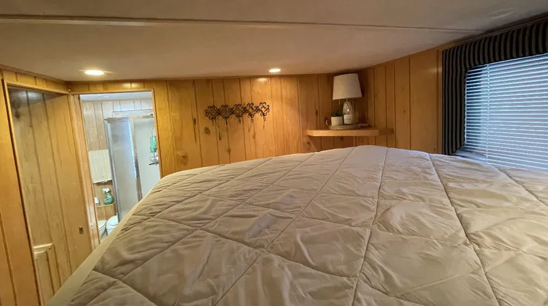 Slide: The Image of Cozy bedroom in 2000 Sumerset 16x75 houseboat with wood paneling and soft lighting. - 16