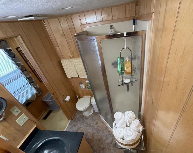 Slide: The Image of Bathroom interior of 2000 Sumerset 16x75 houseboat with shower and wooden paneling. - 17