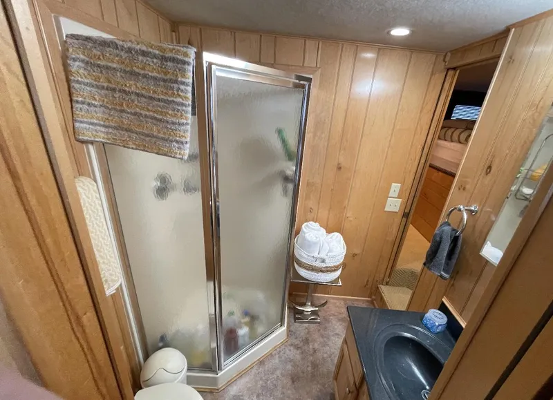 Slide: The Image of Bathroom interior of 2000 Sumerset 16x75 houseboat with wood paneling and shower. - 18