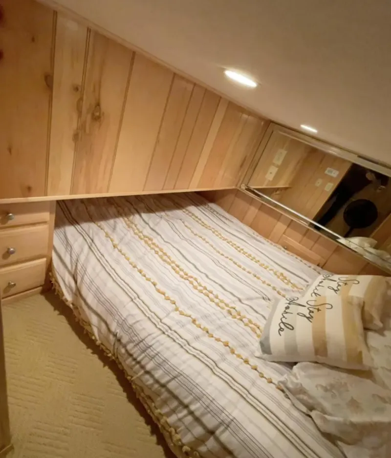 Slide: The Image of Cozy bedroom in 2000 Sumerset 16x75 houseboat with wood paneling and striped bedding. - 19