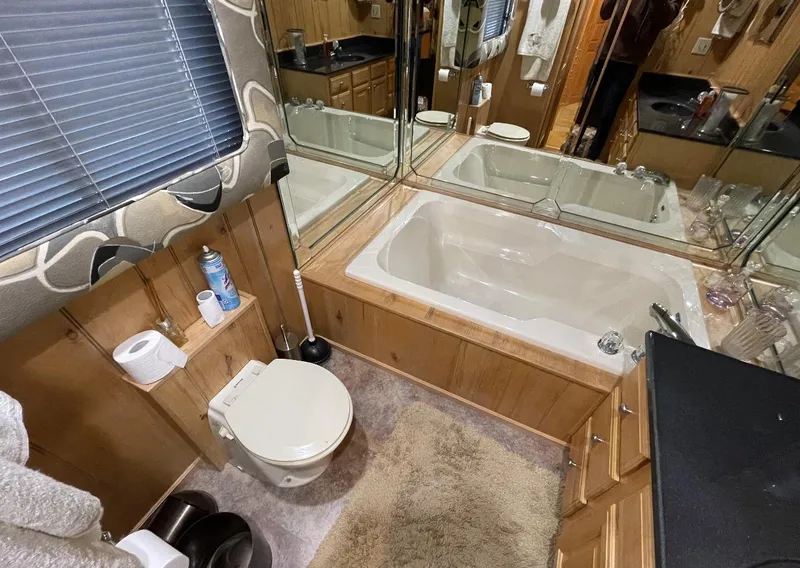 Slide: The Image of Bathroom in 2000 Sumerset 16x75 houseboat with tub, toilet, and mirrored cabinets. - 24