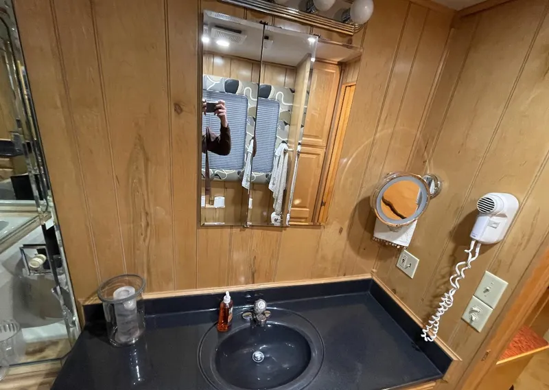 Slide: The Image of Bathroom vanity in 2000 Sumerset 16x75 houseboat with wood paneling and black countertop. - 26