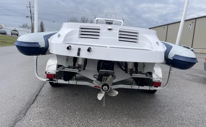 Slide: The Image of 2022 Airship 300 DS boat on trailer, rear view, overcast sky. - 10
