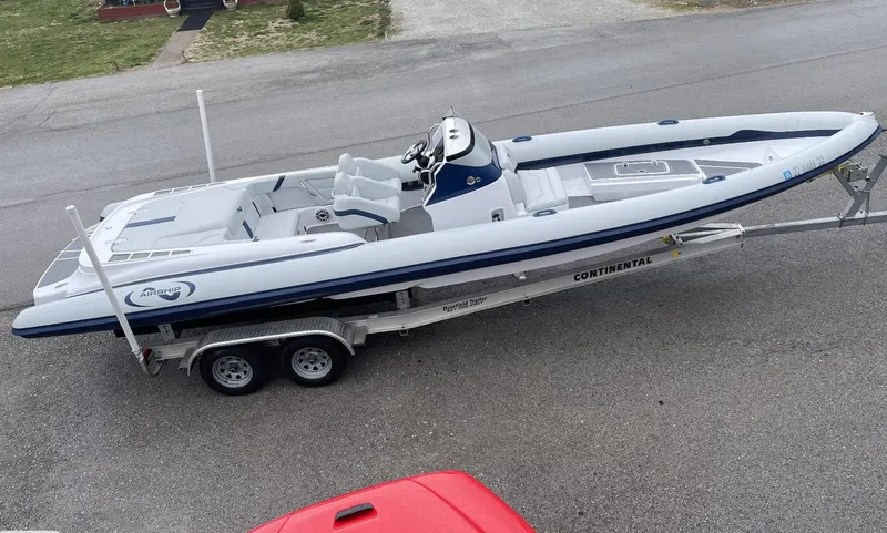 Slide: The Image of 2022 Airship 300 DS boat on trailer, parked on a road. - 13
