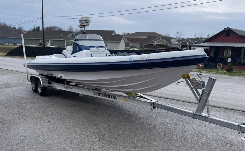 Slide: The Image of 2022 Airship 300 DS boat on trailer, parked on a residential street. - 14