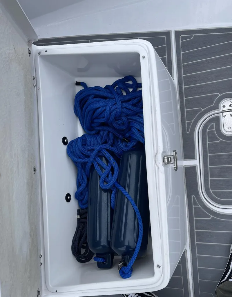 Slide: The Image of Open storage compartment on 2022 Airship 300 DS with blue ropes and fenders. - 18