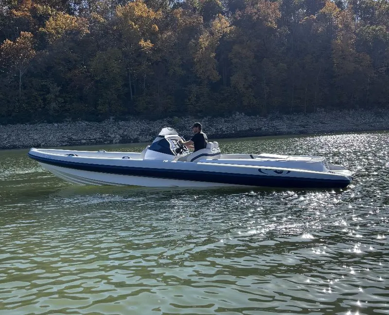Slide: The Image of 2022 Airship 300 DS boat cruising on a sunny lake with forested shoreline. - 2
