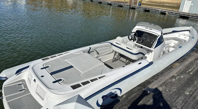 Slide: The Image of 2022 Airship 300 DS boat docked on calm water. - 4