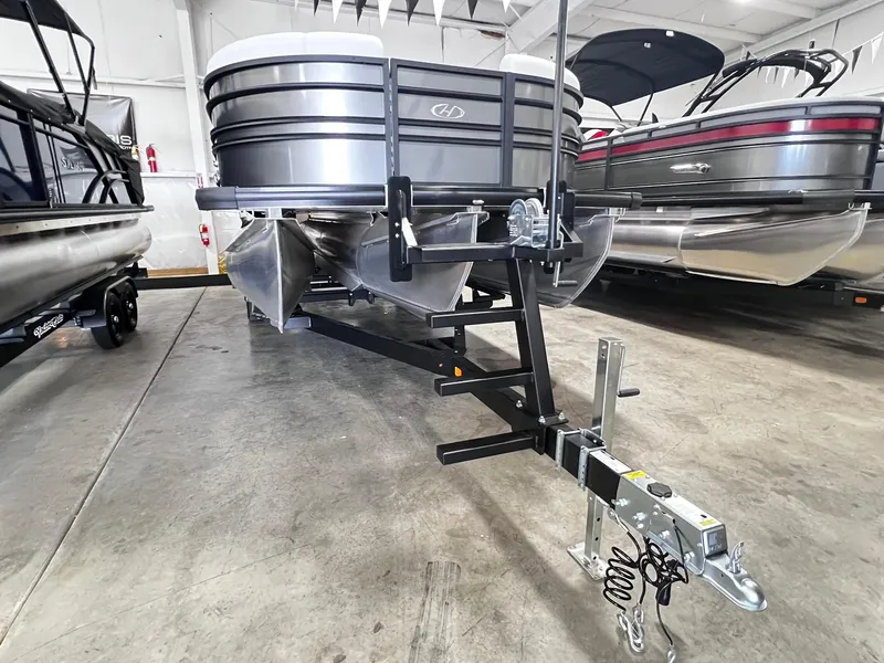 Slide: The Image of 2024 Harris Sunliner 250 pontoon boat on trailer in showroom. - 28