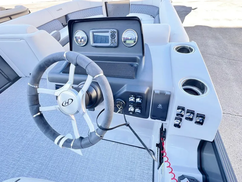 Slide: The Image of 2024 Harris Sunliner 250 boat dashboard with steering wheel and control panel. - 6