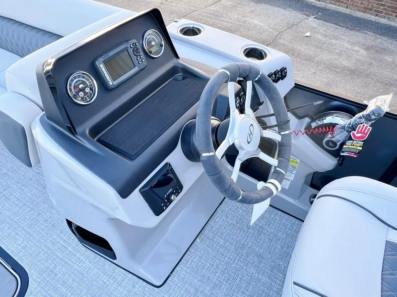 Slide: The Image of 2024 Harris Sunliner 250 boat dashboard with steering wheel and control panel. - 7
