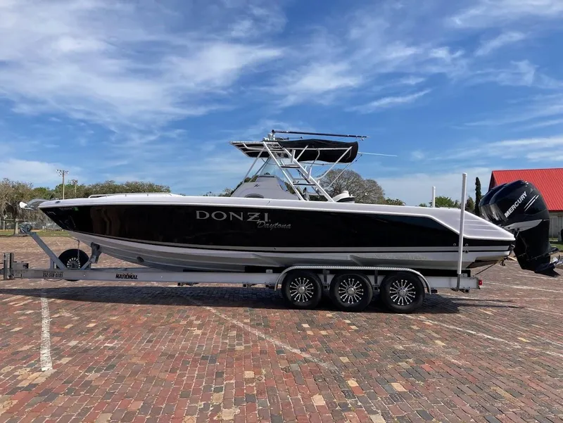 Slide: The Image of 2005 Donzi 35 ZFC Daytona boat on trailer, parked on brick pavement under blue sky. - 1