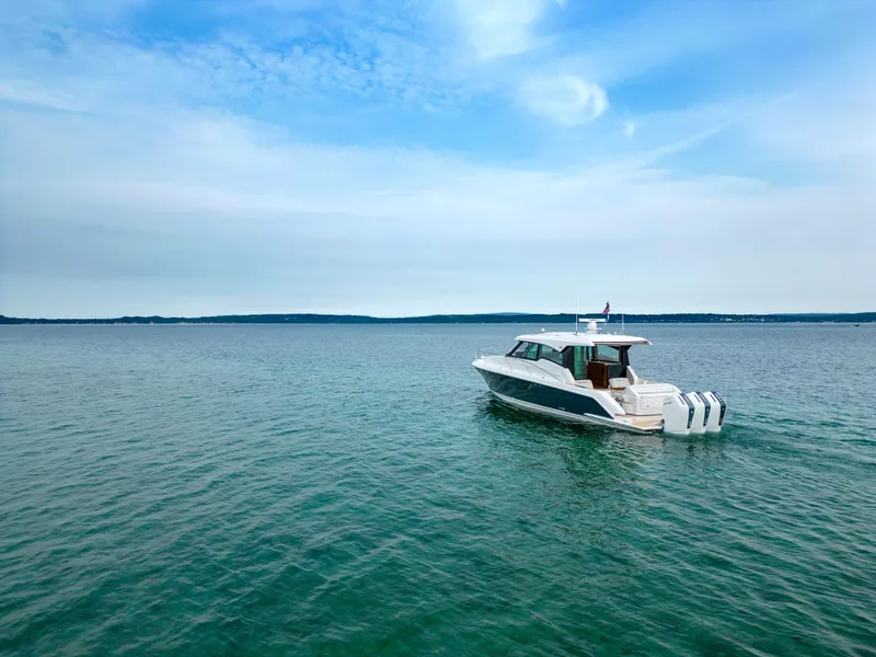 Slide: The Image of 2025 Tiara Yachts 48LE cruising on open water under a clear sky. - 13
