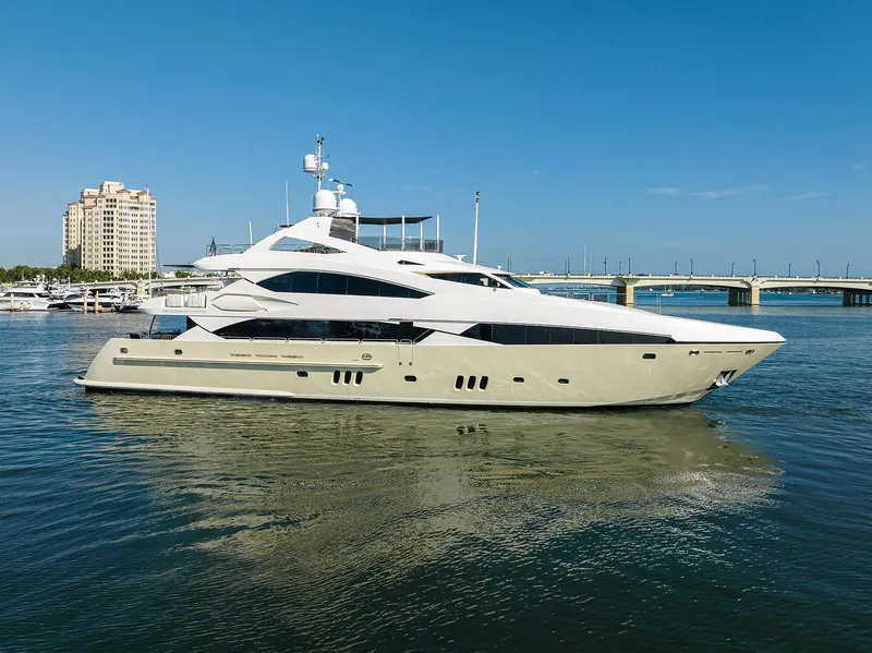 Slide: The Image of 2009 Sunseeker Trideck yacht cruising in a marina with a bridge and buildings in the background. - 1