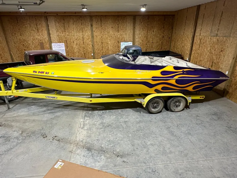 Slide: The Image of 2005 Eliminator 260 Eagle XP boat with yellow and purple flame design on trailer. - 0
