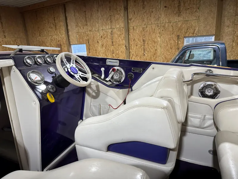 Slide: The Image of 2005 Eliminator 260 Eagle XP boat interior with white seats and dashboard controls. - 14