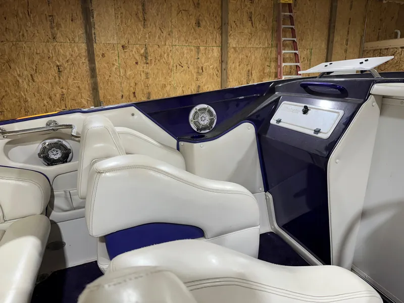 Slide: The Image of 2005 Eliminator 260 Eagle XP boat interior with white seats and blue accents. - 19