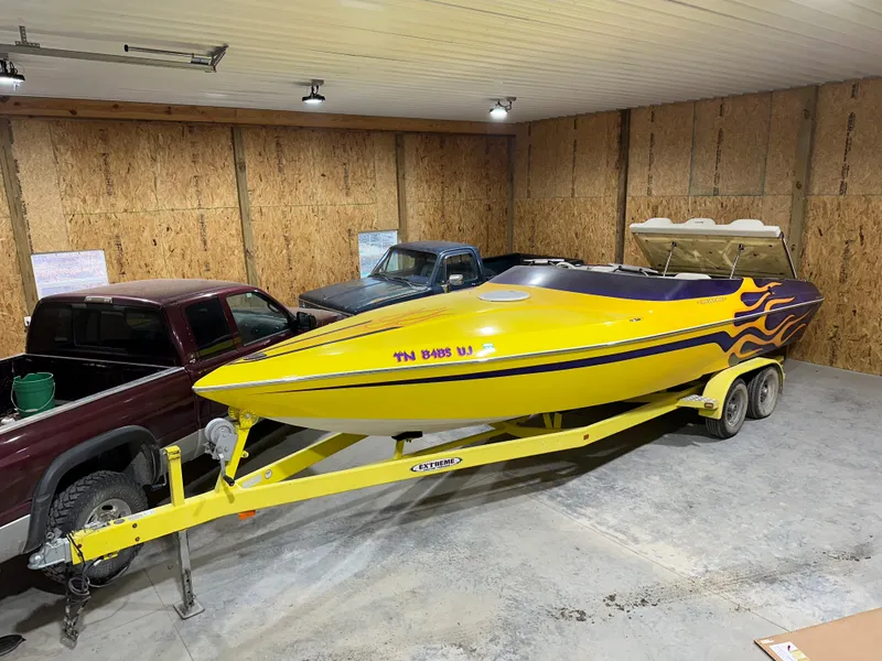 Slide: The Image of Yellow 2005 Eliminator 260 Eagle XP boat with flame decals in a garage. - 2
