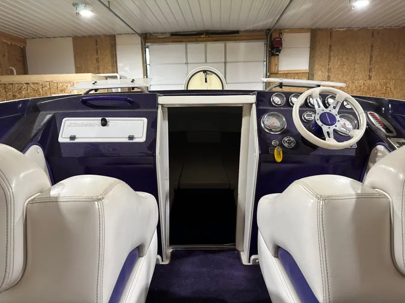 Slide: The Image of 2005 Eliminator 260 Eagle XP boat interior with white seats and dashboard controls. - 23