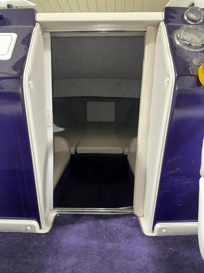 Slide: The Image of 2005 Eliminator 260 Eagle XP cabin interior with purple accents and seating area. - 25