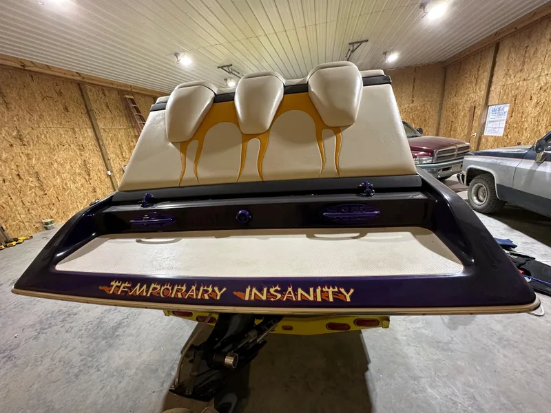 Slide: The Image of 2005 Eliminator 260 Eagle XP boat with "Temporary Insanity" text, stored indoors. - 35