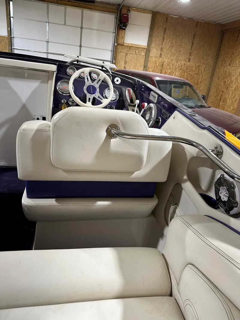 Slide: The Image of 2005 Eliminator 260 Eagle XP boat interior with white seating and steering wheel. - 43