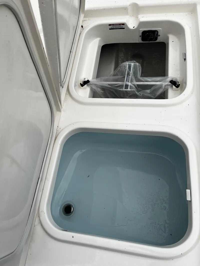 Slide: The Image of 2024 Robalo 266 Cayman boat storage compartments and livewell. - 18