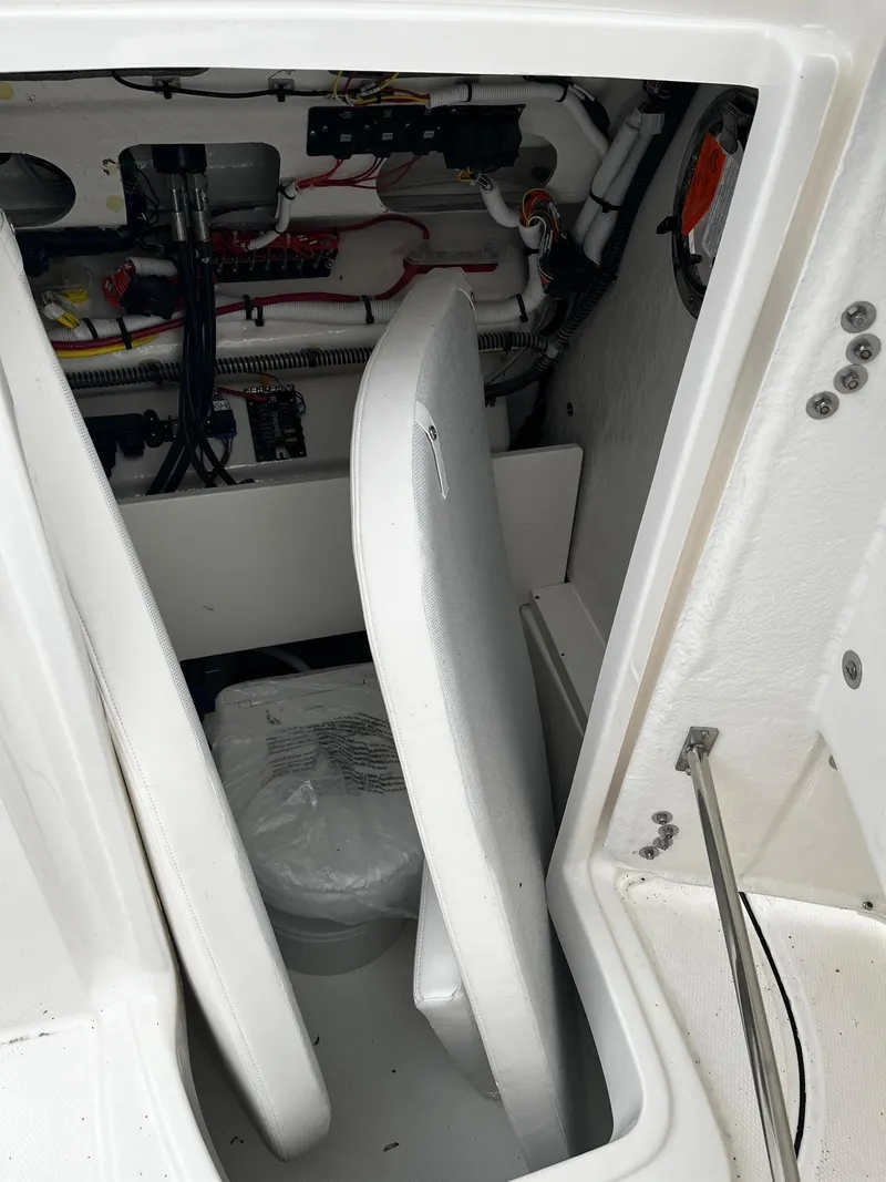 Slide: The Image of 2024 Robalo 266 Cayman boat storage compartment with electrical components. - 20