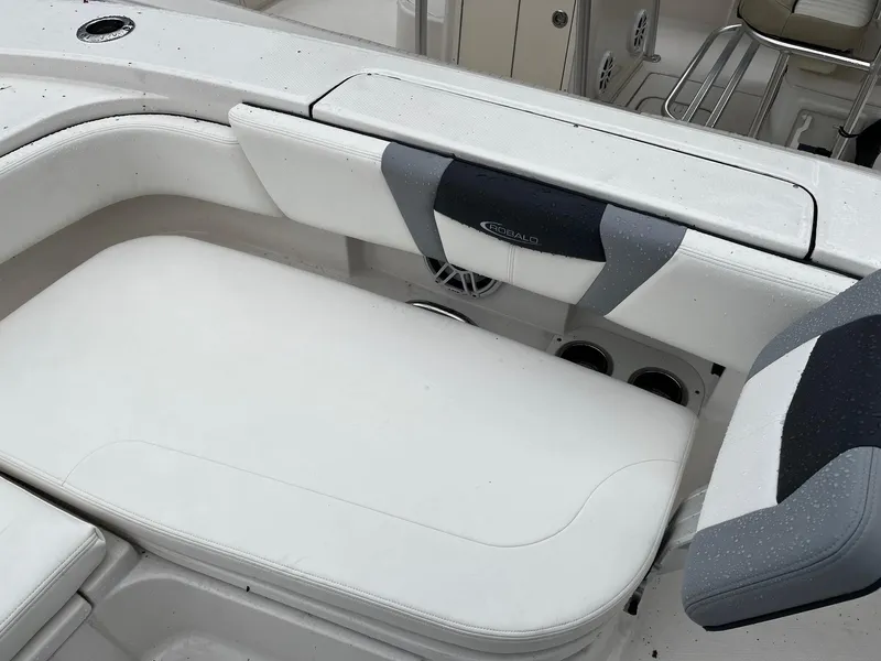 Slide: The Image of 2024 Robalo 266 Cayman boat interior seating area with white and gray cushions. - 14