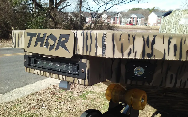 Slide: The Image of 2023 Thor Lake Hammer Elite boat with camouflage design and LED lights. - 4
