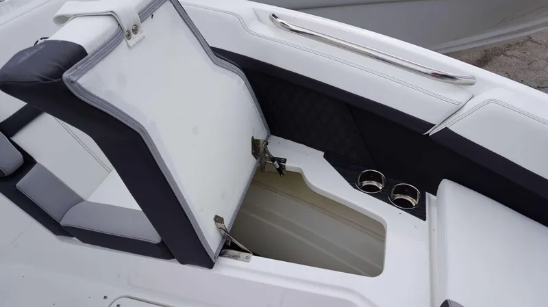 Slide: The Image of 2023 Cobalt R8 boat interior with open storage compartment and cup holders. - 13