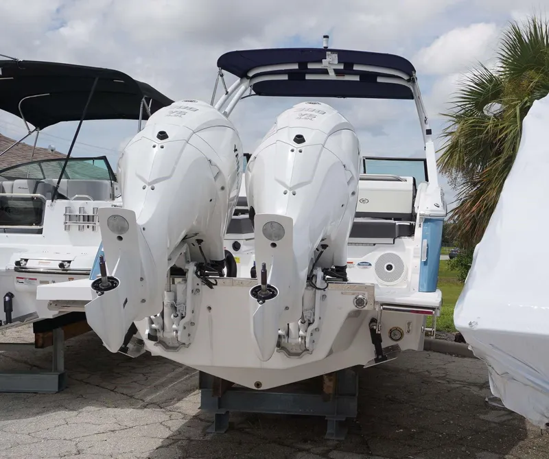 Slide: The Image of 2023 Cobalt R8 boat with dual outboard engines, docked under a cloudy sky. - 16