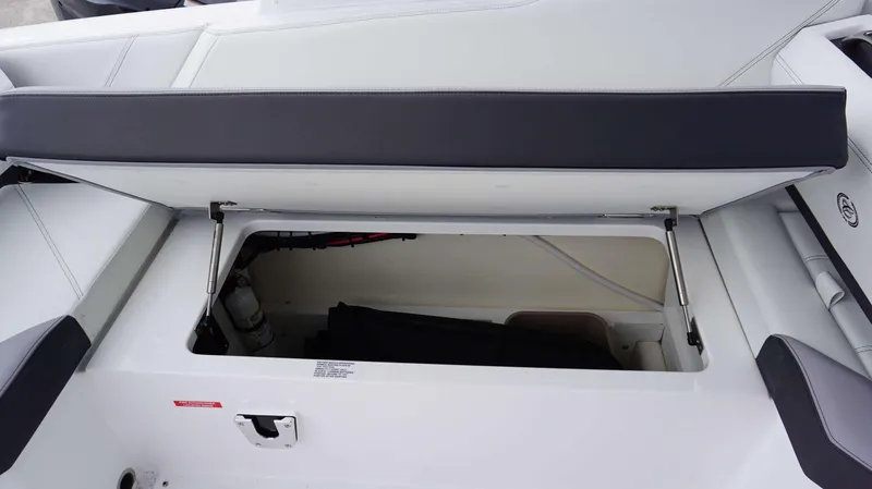 Slide: The Image of 2023 Cobalt R8 boat storage compartment with open seat revealing interior space. - 19