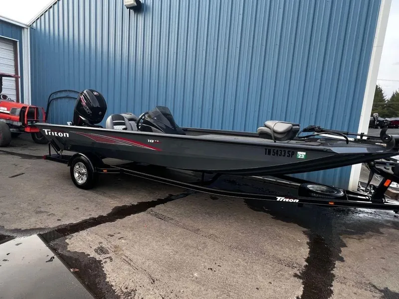 Slide: The Image of 2020 Triton 18 TX fishing boat parked outside a blue building. - 3