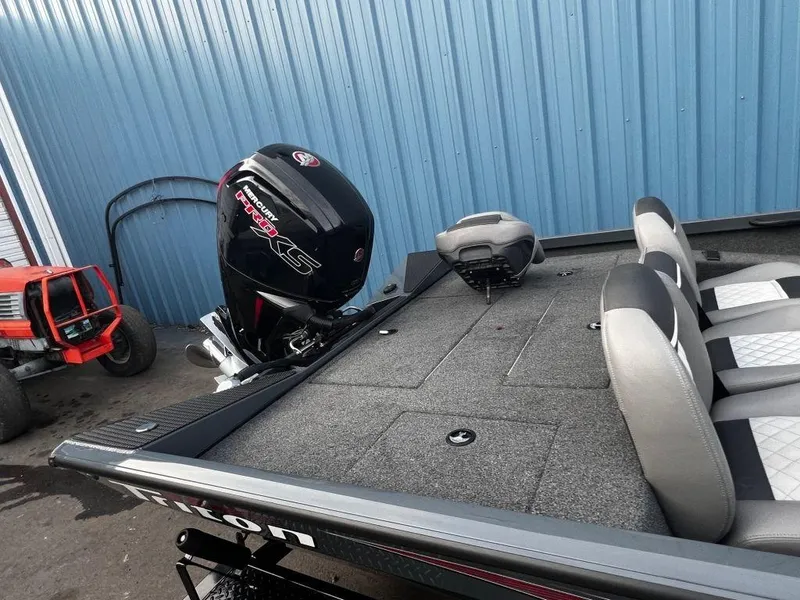 Slide: The Image of 2020 Triton 18 TX boat with Mercury Pro XS engine, docked near blue metal wall. - 9