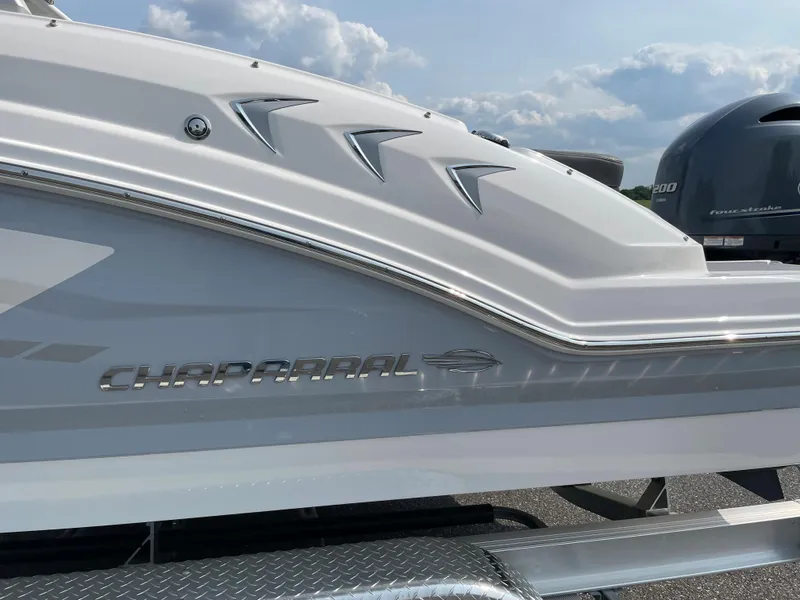 Slide: The Image of 2024 Chaparral 23 SSi OB boat side view with logo and engine. - 10