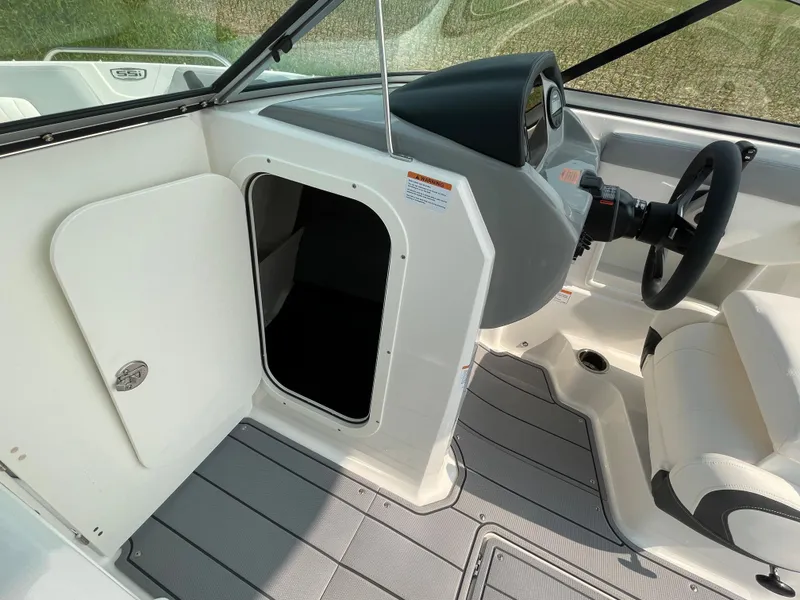 Slide: The Image of 2024 Chaparral 23 SSi OB boat interior with storage compartment and steering console. - 25