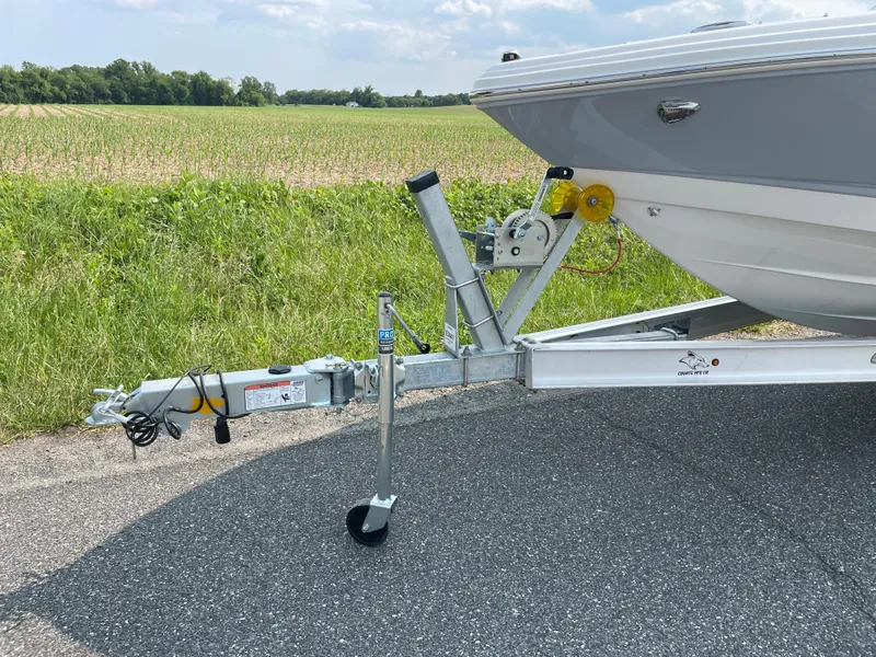 Slide: The Image of 2024 Chaparral 23 SSi OB boat on a trailer, parked on a rural road. - 3