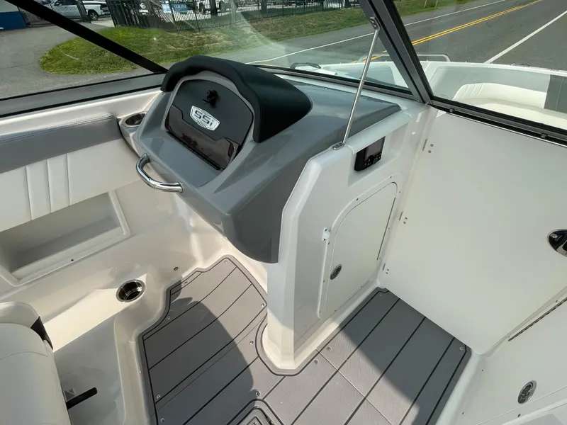 Slide: The Image of 2024 Chaparral 23 SSi OB boat interior, featuring helm station and seating area. - 32