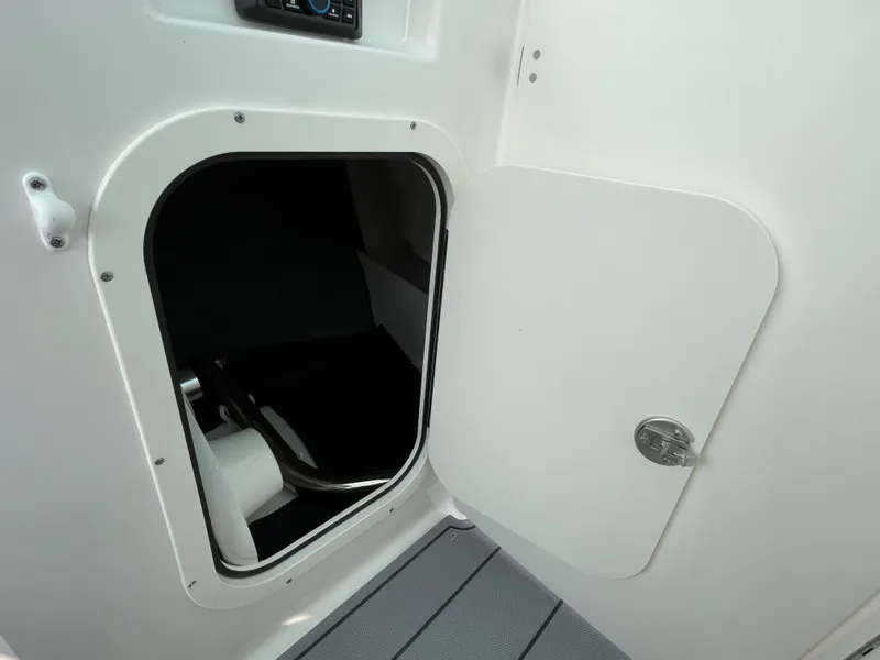 Slide: The Image of 2024 Chaparral 23 SSi OB boat storage compartment with open door. - 34