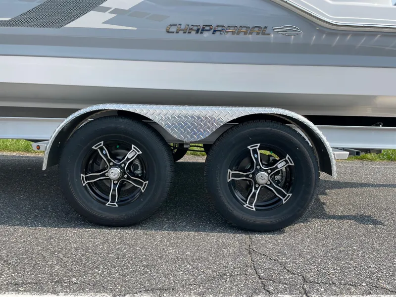 Slide: The Image of 2024 Chaparral 23 SSi OB boat on a dual-axle trailer with black alloy wheels. - 6